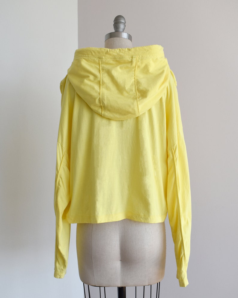 Yellow hoodie in lightweight t-shirt cotton, tonal piping along sleeves and chest, drawstring with silver endings