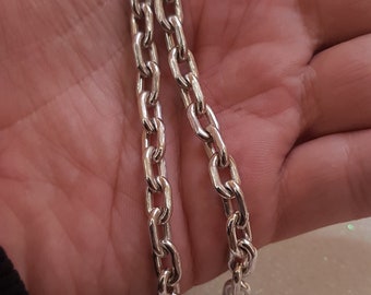 May include: A silver chain necklace with a curb link design.