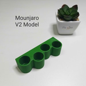 May include: A green plastic 3D printed organizer with four compartments. The organizer is labeled "Mounjaro V2 Model".