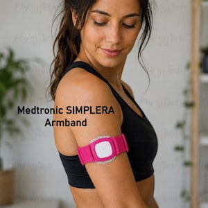 May include: A Medtronic SIMPLERA Armband featuring a bright pink fabric strap and a central white square sensor unit. The device is designed to be worn securely around the upper arm, providing a compact and functional medical monitoring solution.