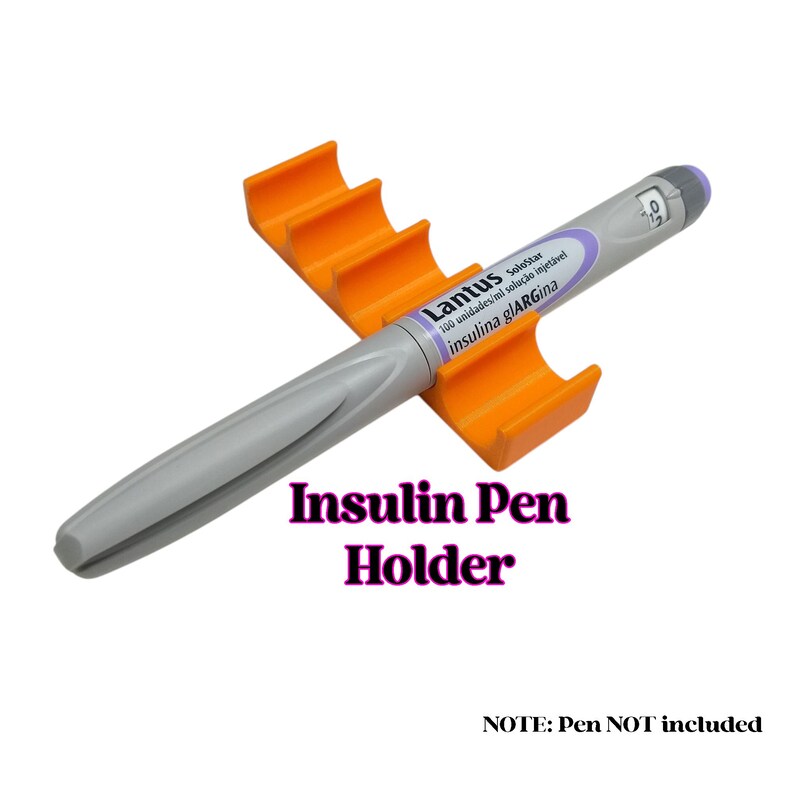 May include: Orange plastic insulin pen holder with four slots. The holder is empty, but a gray insulin pen is shown next to it. The pen has the text "Lantus SoloStar 100 unidades/ml solu&ccedil;&atilde;o injet&aacute;vel insulina glARGina" on it. The text "NOTE: Pen NOT included" is also visible.