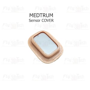 Op de afbeelding: Een beige sensorafdekking met de tekst "MEDTRUM Sensor COVER". De afdekking heeft een rechthoekige vorm met afgeronde hoeken en een verhoogde rand. Het midden is lichter van kleur.