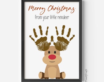 May include: A printable Christmas card featuring a reindeer made with handprints. The reindeer is brown with a red nose and the text "Merry Christmas from your little reindeer" is at the top of the card.