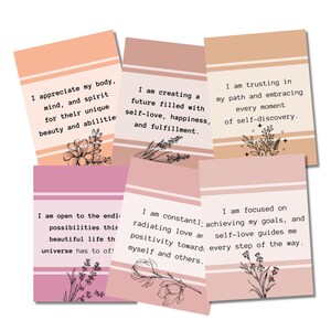 May include: Six pink and peach affirmation cards with black text and floral illustrations. The text on the cards reads: "I appreciate my body, mind, and spirit for their unique beauty and abilities", "I am creating a future filled with self-love, happiness, and fulfillment", "I am trusting in my path and embracing every moment of self-discovery", "I am open to the endless possibilities this beautiful life has to offer", "I am constantly radiating love and positivity toward myself and others", "I am focused on achieving my goals, and self-love guides me every step of the way."