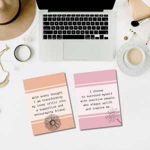 May include: Two pink and peach colored affirmation cards with inspirational quotes. The first card says "With every thought I am transforming my inner critic into a supportive and encouraging friend." The second card says "I choose to surround myself with positive people who always uplift and inspire me."