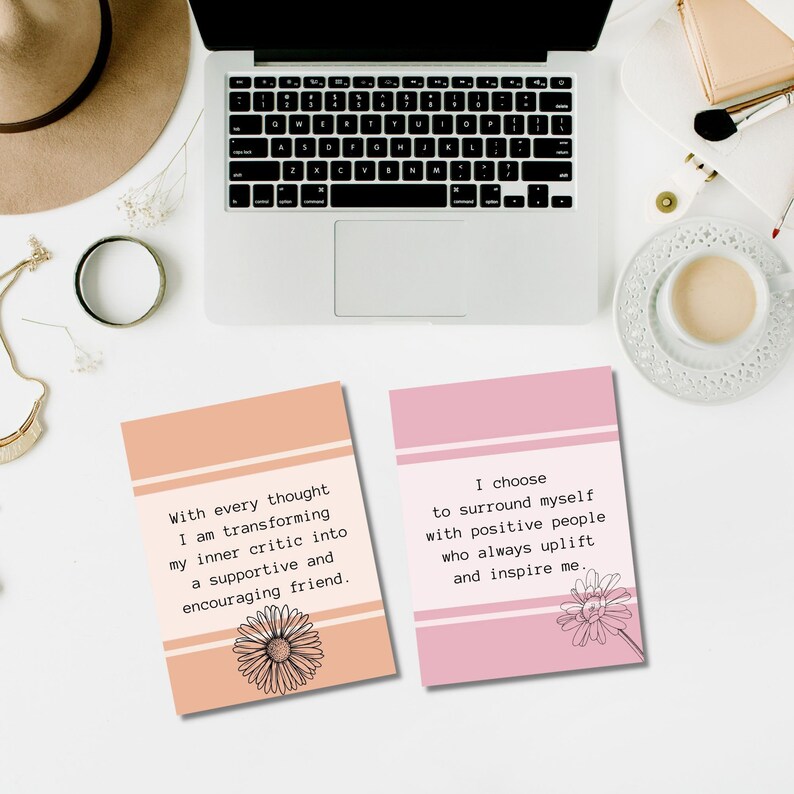 May include: Two pink and peach colored affirmation cards with inspirational quotes. The first card says "With every thought I am transforming my inner critic into a supportive and encouraging friend." The second card says "I choose to surround myself with positive people who always uplift and inspire me."