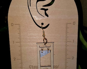 Pendientes de guillotina: Joyería ligera de madera con humor negro. Sin reyes.