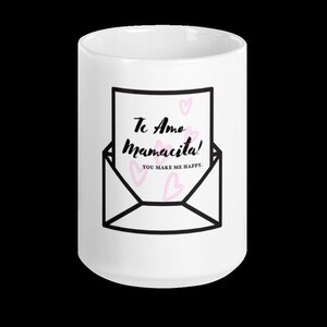 May include: White ceramic mug with a black and white illustration of an envelope with a handwritten note that says "Te Amo Mamacita! You make me happy."  Pink hearts are scattered around the note.