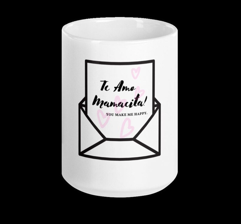 May include: White ceramic mug with a black and white illustration of an envelope with a handwritten note that says "Te Amo Mamacita! You make me happy."  Pink hearts are scattered around the note.