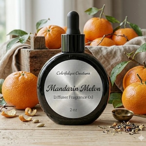 May include: A black diffuser fragrance oil bottle with a silver label that reads "Mandarin Melon." The bottle is surrounded by fresh oranges and greenery. The label also says "Colorfulque Creations" and "2 oz."