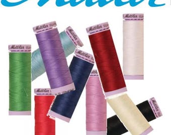 May include: Assortment of spools of thread in various colors, including green, blue, purple, red, white, cream, pink, and black. The spools are labeled "Metzler" and are arranged in a random pattern.