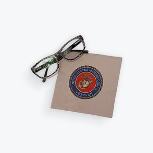 Op de afbeelding: Een bruine microvezel schoonmaakdoek met een blauw en rood logo van de United States Marine Corps Veteran.