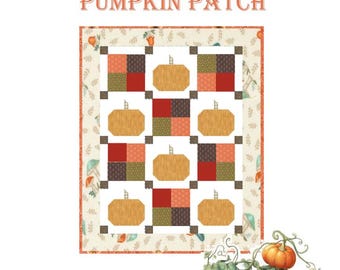 Pode incluir: Um edredom de retalhos com tema de abóbora. O edredom apresenta grandes abóboras laranja e quadrados de tecido vermelho, marrom e verde. As palavras "PUMPKIN PATCH" estão no topo. Uma borda decorativa e uma videira de abóbora também são visíveis.