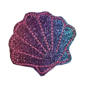 May include: A pink, purple, and blue glitter seashell with pink stitching. The seashell is a decorative patch.