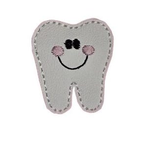 May include: A gray felt tooth with a pink and black embroidered smiley face.