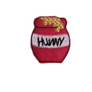May include: Red felt honey pot with a gold felt honey drip and the word "HONEY" embroidered in black on a white band.