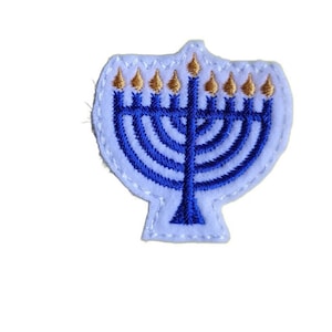 May include: A blue and gold embroidered menorah patch. The menorah has nine candles and is surrounded by a white border.