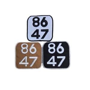May include: Three embroidered patches with the numbers 86 and 47. The patches are in white, brown, and black.