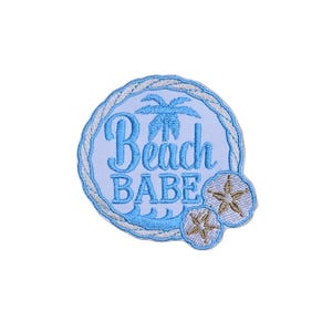 May include: Blue and white embroidered patch with the text "Beach Babe" and a palm tree design. The patch is surrounded by a rope-like border and features two embroidered seashells.