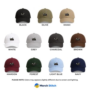 May include: A collection of twelve baseball caps in various colors including black, olive, khaki, white, grey, charcoal, brown, maroon, forest, light blue, and navy. Each cap features an embroidered graphic of a black cat peeking over the brim.