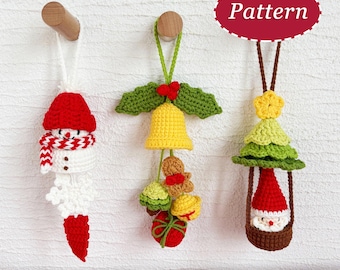 May include: Three handmade crochet Christmas ornaments. The snowman has a red hat and scarf. The bell ornament is yellow with green leaves and a red bow. The tree ornament has a Santa Claus figure inside.