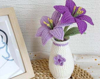 May include: A crocheted vase with a purple flower design and a bouquet of purple crocheted lilies.