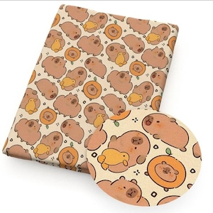 May include: A folded fabric with a repeating pattern of cartoon capybaras, ducks, and orange circles on a cream background. The capybaras are brown, the ducks are yellow, and the circles are orange. A circular swatch shows a close-up of the pattern.