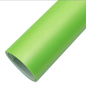 May include: A roll of bright green faux leather material. The material has a textured surface and is rolled up, revealing a light-colored interior. The color is a vibrant, solid green.