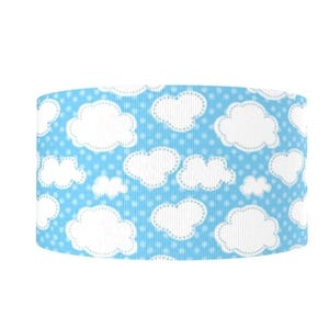 May include: A blue ribbon with a white cloud pattern and small white polka dots. The clouds have a stitched outline. The ribbon is a solid color and is suitable for crafts and decorations.