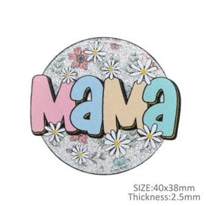 May include: A round, glittery badge with the word "Mama" in pastel colors. The letters are outlined in black and surrounded by white daisies and floral patterns. The badge measures approximately 1.57 x 1.5 inches and is 0.1 inches thick.