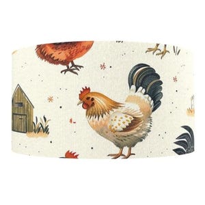 May include: A cylindrical lampshade featuring a repeating pattern of watercolor farm animals. The design includes a rooster, a hen, a small barn, and foliage in shades of brown, orange, and green on a cream background.