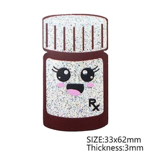 May include: A brown and silver glitter pill bottle with a smiling face and the letters "Rx". The bottle is 33x62mm and 3mm thick. The bottle has a silver glitter cap with vertical lines.