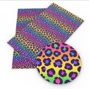 May include: A rectangular sheet of craft material featuring a vibrant rainbow gradient background overlaid with a repeating dark purple leopard print pattern, accompanied by a circular inset showing a magnified view of the colourful animal spots.