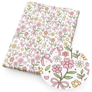 May include: A rectangular fabric with a repeating floral pattern. The design features pink and yellow flowers, green leaves, and pink bows on a white background. Small hearts and stars are also scattered throughout the design.