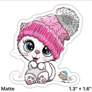 May include: A matte sticker of a cartoon white cat wearing a pink knitted hat with a grey pom-pom. The cat has large blue eyes and is sitting with a small bird wearing a blue hat. The sticker measures 3.3 cm x 4.1 cm.