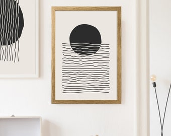 May include: Two black and white abstract art prints with a minimalist design. The prints feature a circle with lines radiating from it. The prints are framed in white and wood.