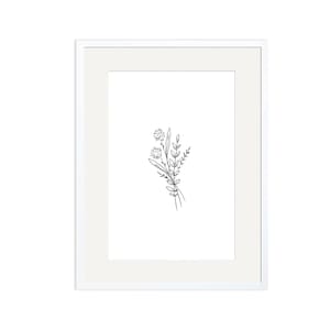 May include: A framed art print featuring a minimalist botanical illustration. The artwork showcases a delicate black and white line drawing of a small bouquet of flowers and leaves. The print is set within a white mat and a white frame.