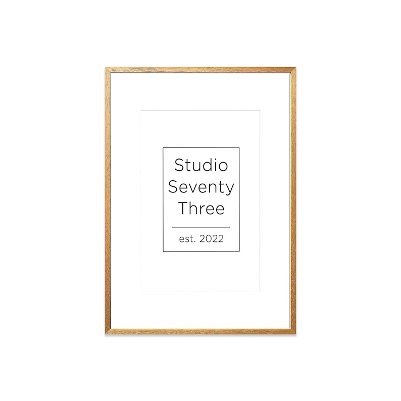 May include: A gold-colored frame with a white mat and the text "Studio Seventy Three est. 2022" printed in black.