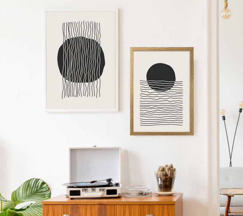 May include: Two black and white abstract line art prints with circles. The print on the left has vertical lines and a circle in the center. The print on the right has horizontal lines and a circle above the lines.