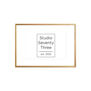 May include: A gold-colored frame with a white mat and a black and white logo that reads "Studio Seventy Three est. 2022".