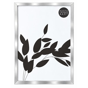 May include: A rectangular photo frame with a metallic silver finish. The frame contains a white insert featuring a black graphic of leafy branches and a circular black logo in the top right corner with the text PHOTO FRAMES & ART.