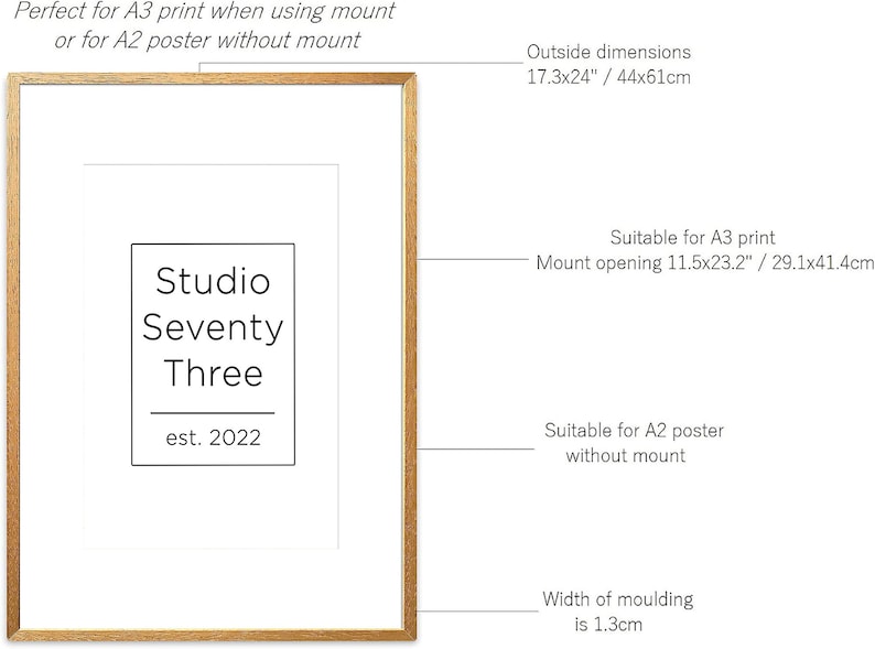 May include: A gold-colored picture frame with a white mat. The frame is 17.3 inches by 24 inches and has a 1.3 inch wide molding. The frame is suitable for an A3 print with a mount or an A2 poster without a mount. The mount opening is 11.5 inches by 23.2 inches. The frame has a logo that says "Studio Seventy Three est. 2022".