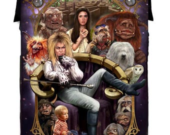 Può includere: Una coperta con una scena di un film fantasy con più personaggi. La figura centrale è una persona con lunghi capelli biondi, seduta su un trono. Varie creature e un labirinto sono sullo sfondo. La combinazione di colori è principalmente viola, oro e nero.