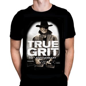 May include: Black t-shirt with a graphic from the film "True Grit", including the text "TRUE GRIT 50TH ANNIVERSARY". The graphic is a monochrome image of a man in a cowboy hat holding a rifle.