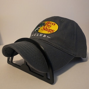 May include: Gray baseball cap with a yellow and red Bass Pro Shops logo and the text "CLUB" embroidered on the front.