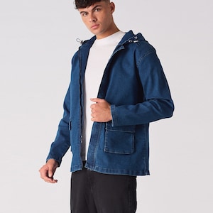 May include: A blue denim jacket with a hood and pockets. The jacket is zipped up and has a white t-shirt underneath.