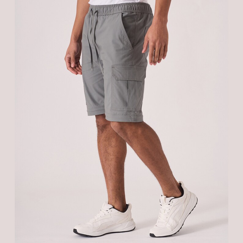 May include: A pair of gray cargo shorts with a drawstring waist and multiple pockets. The shorts are made of a lightweight fabric and are perfect for casual wear.
