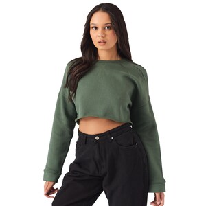 May include: A green cropped sweatshirt with long sleeves and a relaxed fit.
