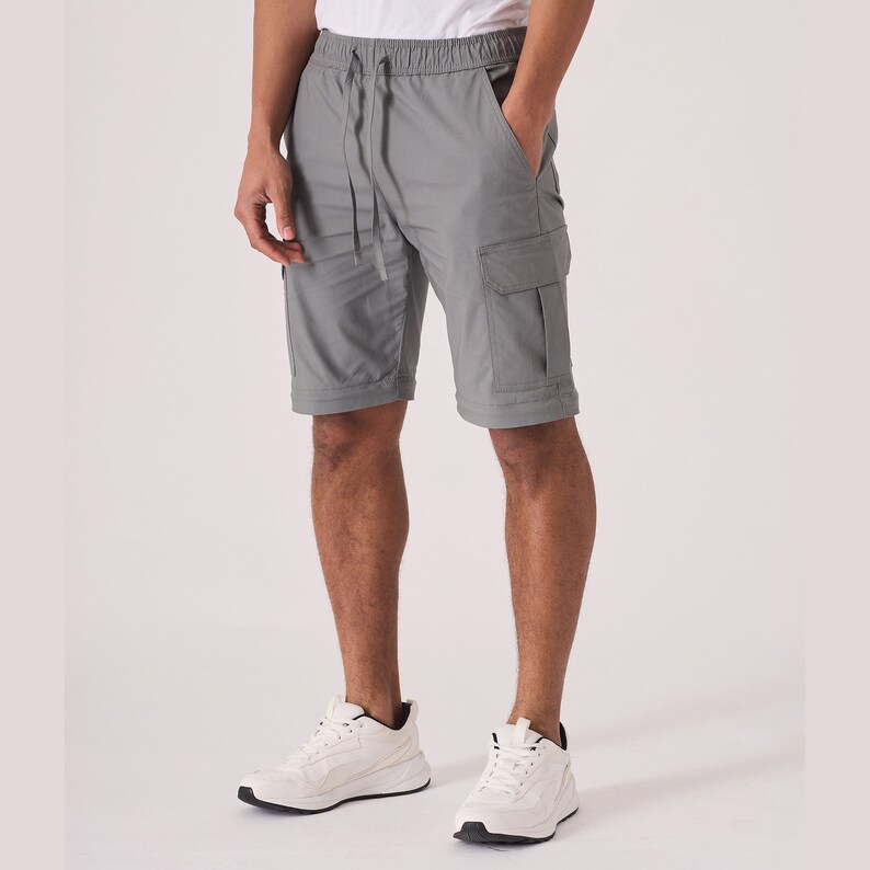 May include: Gray cargo shorts with a drawstring waist and multiple pockets. The shorts are made of a lightweight fabric and are perfect for casual wear.