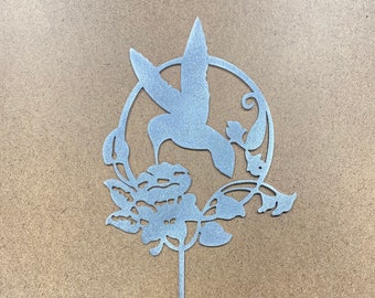 May include: Silver metal hummingbird garden stake with a circular design featuring a hummingbird in flight, a flower, and leaves.